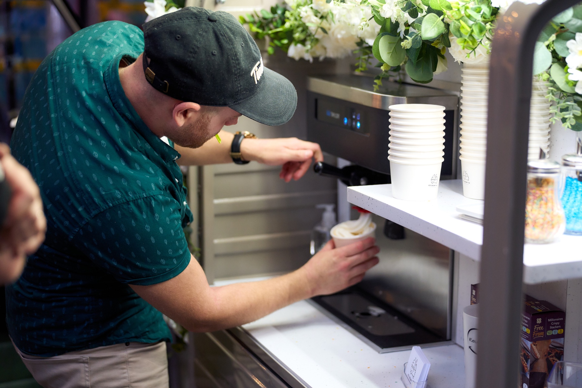 Attendant serving soft-serve ice cream from the tuk-tuk