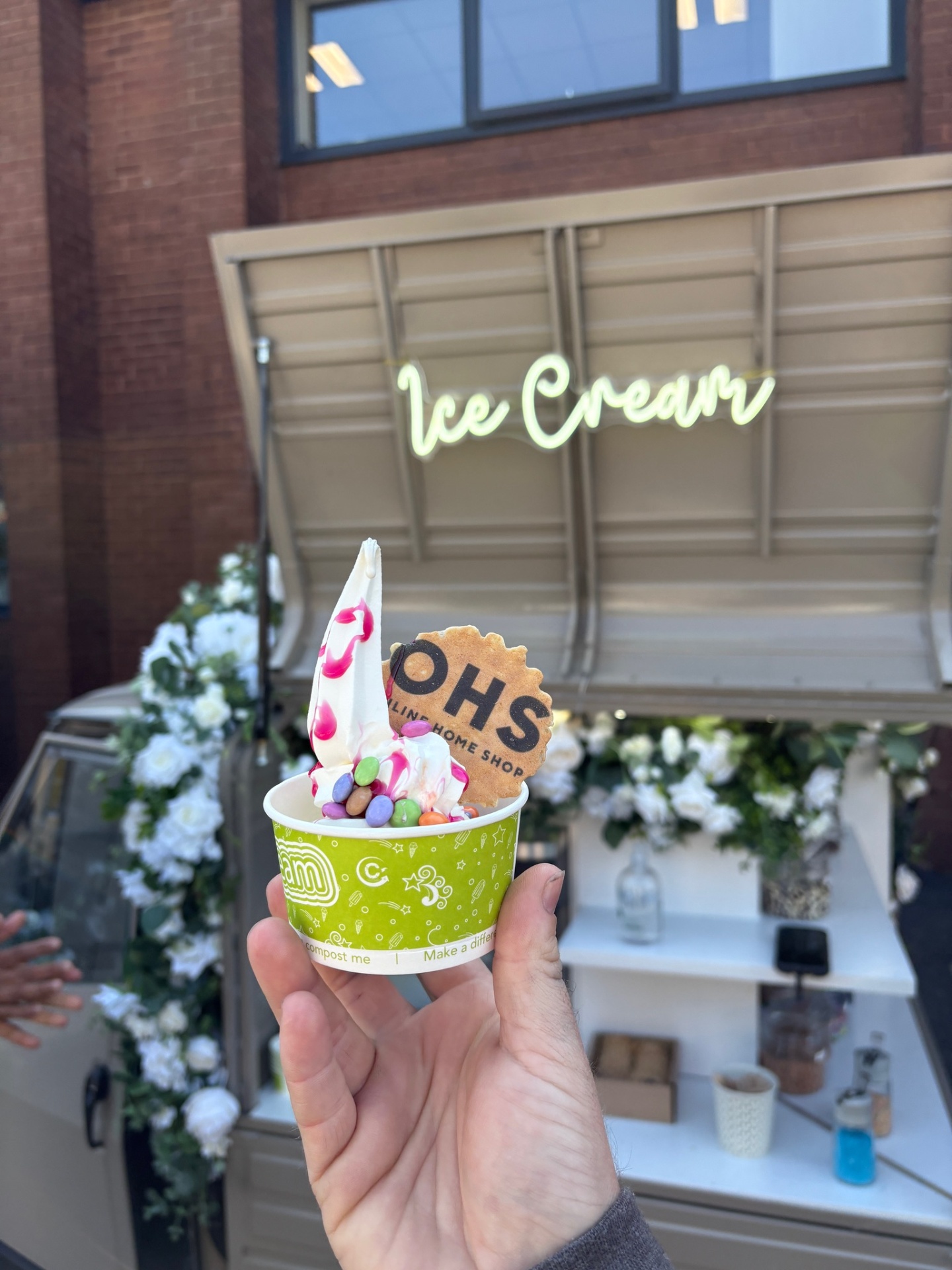 A cup of soft-serve with sprinkles and toppings